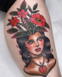 a tattoo of a woman with flowers in her head