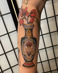 a tattoo of a vase with flowers on it